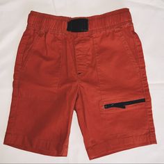 Wonder Nation Rip Stop Elastic Waist Buckle Shorts. Like New Shorts Had The Tags Taken Off But Were Never Worn. Five Pockets, With The Pocket On The Leg Having A Zipper Closure. Buckle In Front Is Not Adjustable. Dark, Almost Burnt Orange Color. Boys Size Small 6-7 Spring School Shorts With Pockets, School Stretch Shorts, Short Playwear Shorts With Pockets, Short Shorts With Pockets For Playwear, School Cotton Shorts With Pockets, Cotton School Shorts With Pockets, Orange Cotton Bottoms For Playwear, Red Casual Shorts For School, Casual Red Shorts For School