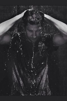 a man standing in the rain with his hands on his head