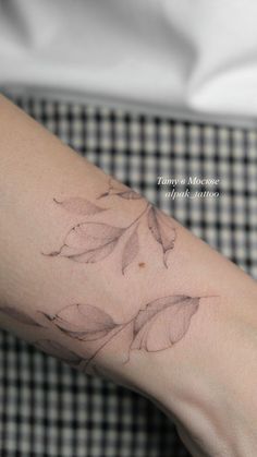 a woman's arm with a flower tattoo on the left side of her arm