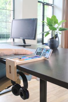 a person sitting at a desk with a tablet and headphones in front of them