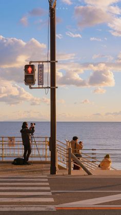 people are taking pictures on the beach by the water's edge with their cameras