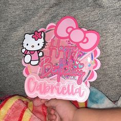 a hello kitty birthday card is held by a baby