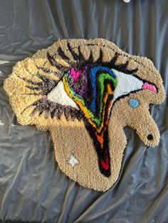 an animal rug is laying on the ground with it's head made out of yarn