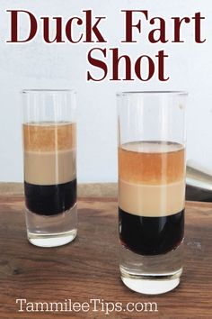 two shot glasses filled with liquid sitting on top of a wooden table next to the words duck fart shot