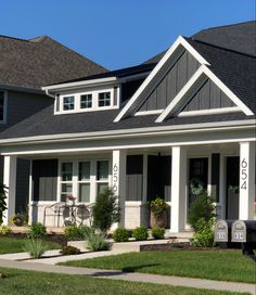 a gray house with white trim and black roof