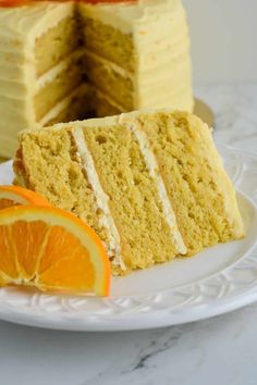 there is a slice of cake on the plate with an orange wedge next to it