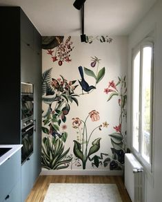 a kitchen with a painted wall and wooden floors