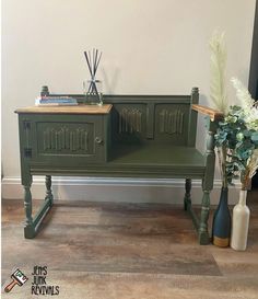 two vases with flowers are sitting next to an old green cabinet and sideboard