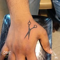 a man's hand with a tattoo on it and a pair of scissors in the middle