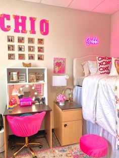 a bedroom decorated in pink and gold with pictures on the wall, desk, and bed