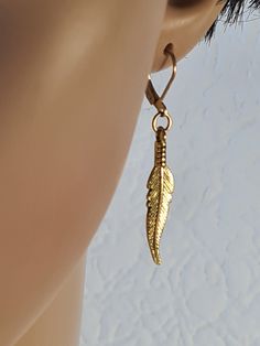 Long feather earring, Antiqued gold feather earring, Men dangle, Symbolic meaning, Gold feather, Dangle earring, Gift for him, Men's earrings, One tibetian silver feather earring in antiqued gold colour. Length 1.3 inches /4.2 cm/ Feather drop 1.3 inches /3,2 cm/ It looks the same in both the right ear and the left ear. One tibetian silver feather earring in antiqued gold colour. Choose 1 of 2 hooks types-lever back or ear wire. NOTE: Delivery time to Europe is 7 to 30 working days. Delivery tim Gold Dangle Cartilage Earrings With Ear Wire, Dangling Earrings Men, Gold Dangle Earrings Men, Dangle Feather Jewelry As A Gift, Men’s Dangle Earring, Feathered Dangle Jewelry As A Gift, Elegant Dangle Earrings With Feathers, Gold Feather Earrings As A Gift, Dangly Earrings Men Feather