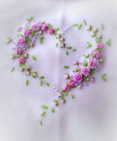 a heart made out of flowers on a white cloth