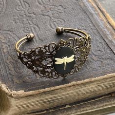 Adjustable dark antiqued brass filigree cuff bracelet with a bee, dragonfly or flower cameo.Cuff is flexible enough to adjust to any wrist.I have matching rings, earrings and necklaces in my shop. Taurus Ring, Bohemian Outfits, Dragonfly Jewelry, Rock Jewelry, Cameo Jewelry, Cameo Ring, Chunky Jewelry, Wrist Cuffs, Bracelet Black