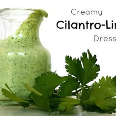 a jar filled with cilantro - lime dressing next to a sprig of parsley