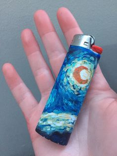 a hand holding a lighter in it's palm with a starry night painting on it