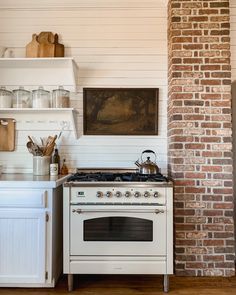 a white stove top oven sitting inside of a kitchen next to a wall mounted oven