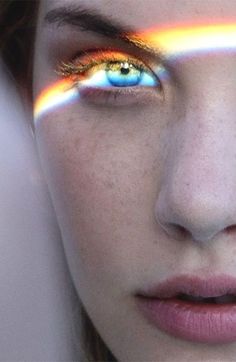 a woman's face with rainbow painted on her eyes