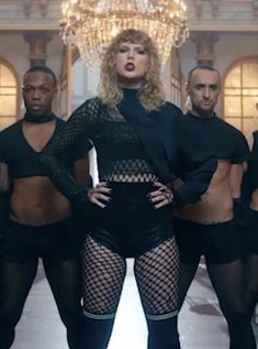 the singer is posing in front of her dancers wearing fishnet stockings and high heels