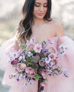 a woman in a pink dress holding a bouquet of flowers