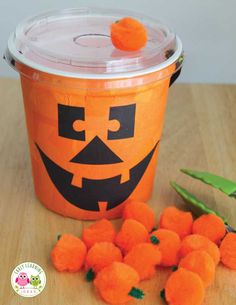 an orange bucket filled with carrots sitting on top of a wooden table