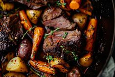 a pot filled with roast, carrots and potatoes