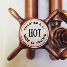 a close up of a hot dog holder on a white wall with the words, chandler & co made in england