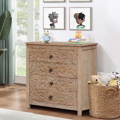 a wooden dresser sitting next to a window with pictures on the wall and stuffed animals