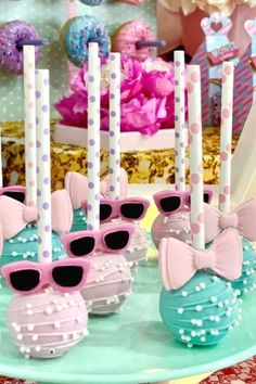 pink and blue cake pops with sunglasses on them are ready to be served at a birthday party