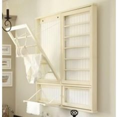 an open bookcase with clothes hanging from it