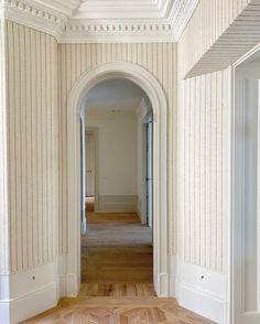 an empty hallway with white walls and wood floors