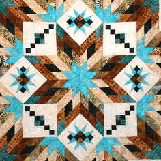 a blue and brown quilt with an intricate design on it's center, in the middle