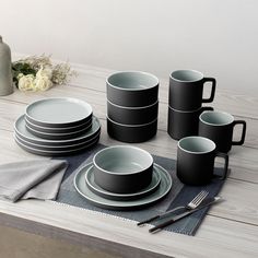 a table set with plates, cups and utensils