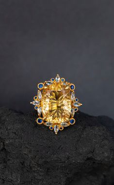 Statement ring with a huge natural yellow citrine framed in intricate lace of blue sapphire and topaz ! It's so stunning on a hand, you will fall in love with it :) ♥ The ring in the video is in size 6 US, the model has rather small hands :) ♥ The design can be made with gemstones of your choosing ♥ Each order will be gift wrapped beautifully ♥ QUALITY: Each item is stamped according to US regulations.  ------   *DIMENSIONS*  ------ ♥ Ring Size: All sizes will be made to order Main Metal: 925 St Luxury Yellow Sapphire Ring, Luxury Citrine Topaz Ring With Gemstone Accents, Luxury Citrine Topaz Ring With Accent Stones, Luxury Topaz And Citrine Ring With Accent Stones, Wedding Ring With Yellow Sapphire And Gemstone Accents, Elegant Yellow Topaz Ring With Gemstone Accents, Luxury Yellow Topaz Ring With Diamonds, Luxury Yellow Oval Sapphire Ring, Exquisite Topaz Ring With Gemstone Accents As Gift