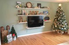 a living room with a christmas tree and tv