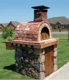 a brick oven sitting on top of a lush green field