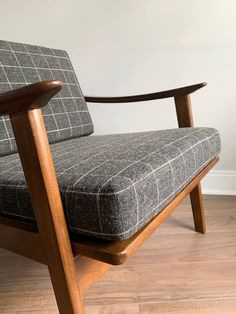 a chair that is sitting on top of a hard wood floor in front of a white wall