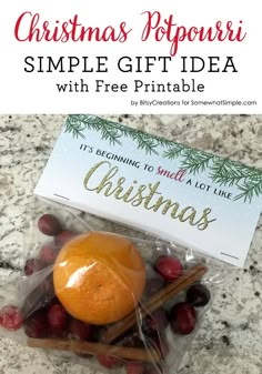 an orange and cinnamon stick wrapped in plastic on top of a counter with christmas decorations