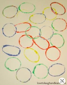 there are many different colored circles on the white paper that is drawn with crayons