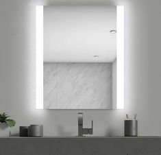 a bathroom sink with a mirror above it and candles on the counter top next to it