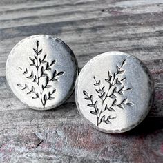 These post earrings are handmade from solid sterling silver.  I have cut a pair of circle discs from a sheet of silver.  I then impressed a sprig leaf into the silver and lightly hammered the borders.  The earrings feature sterling silver posts and sterling silver backings to secure the earrings in place.  The silver has been oxidized and polished to create an antique patina finish. Be sure to see all photos and video for size and finish reference. Circle Size: About 1/2" Total Earring Weight: About 1.4 grams per one earring These sprig leaf earrings make a great gift for a nature lover.  These lightweight studs would be a thoughtful little surprise for someone you love or for a treat to yourself.  Coordinating pieces like those photographed can also be found in my shop. Wise Handmade Jewe Silver Nature-inspired Earrings For Everyday, Silver Everyday Nature-inspired Earrings, Silver Nature-inspired Everyday Earrings, Sterling Silver Round Birth Flower Earrings, Everyday Silver Nature-inspired Earrings, Silver Necklace Designs, Patina Finish, Handmade Jewelry Gift, Gifts For Nature Lovers