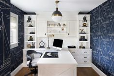 a home office with blue and white wallpaper, built - in desks, and open shelving