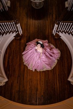 a woman in a pink dress laying on the floor