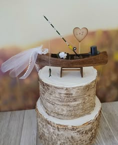 a wedding cake topper with a wooden boat on it and two bride's veils