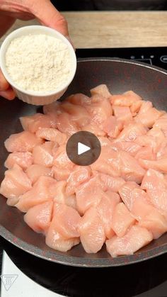 someone is cooking raw fish in a frying pan on the stove top with a measuring cup