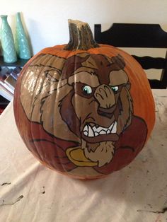 a carved pumpkin with an image of a bear on it's face, sitting on a table