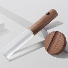 a knife with a wooden handle on a white surface next to two boxes and one piece of paper