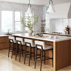 a large kitchen with marble counter tops and wooden stools in front of the island