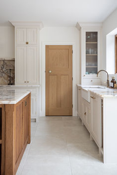 Alnwick Ivory Stone effect porcelain tiles laid in a wooden and white kitchen with marble accents. Natural Stone Floor, Cream Tile