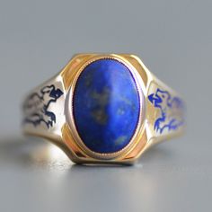 A fabulous antique Art Deco period (1920-1940) sugarloaf lapis lazuli signet ring with cobalt enamel dragons in 14k yellow gold. This wonderful and striking antique ring features a central bezel set oval sugarloaf indigo blue lapis lazuli set north to south in a signet style clipped corner polished gold face that is curved to hug the finger and leads to the most fantastic shoulders with cobalt blue enamel dragons in amazing condition. Ring is hallmarked for 14k gold and engraved "A.C.B. '36". Pl Formal Lapis Lazuli Ring Jewelry, Formal Blue Enamel Ring In 14k Gold, Blue 14k Gold Enamel Ring For Formal Events, Blue 14k Gold Enamel Ring For Formal Occasions, Formal Blue Inlay Jewelry, Art Deco Blue Cabochon Rings, Blue Cabochon Rings Art Deco Style, Blue Cabochon Art Deco Rings, Blue Art Deco Rings With Cabochon