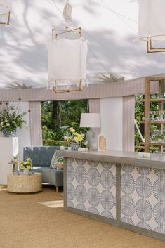 a room filled with furniture and decor under a white awning over a blue couch